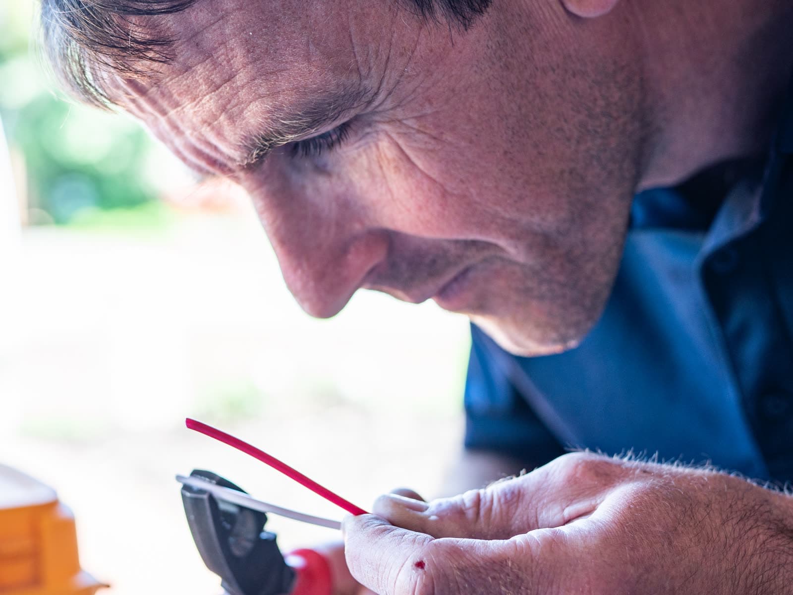 An electrician stripping a wire with pliers